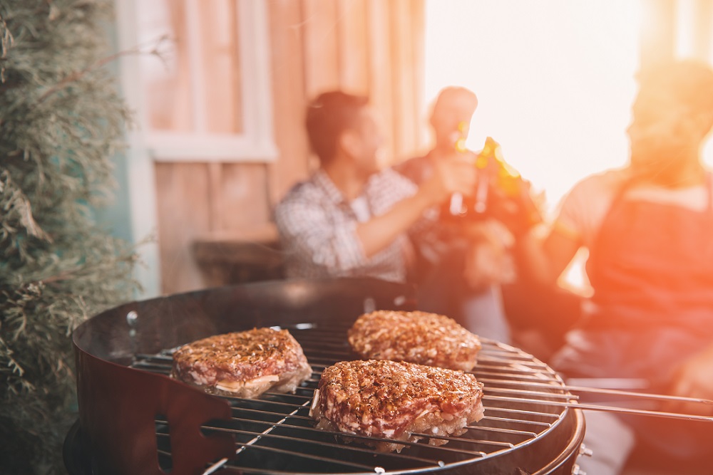barbecue grill with male friends in background