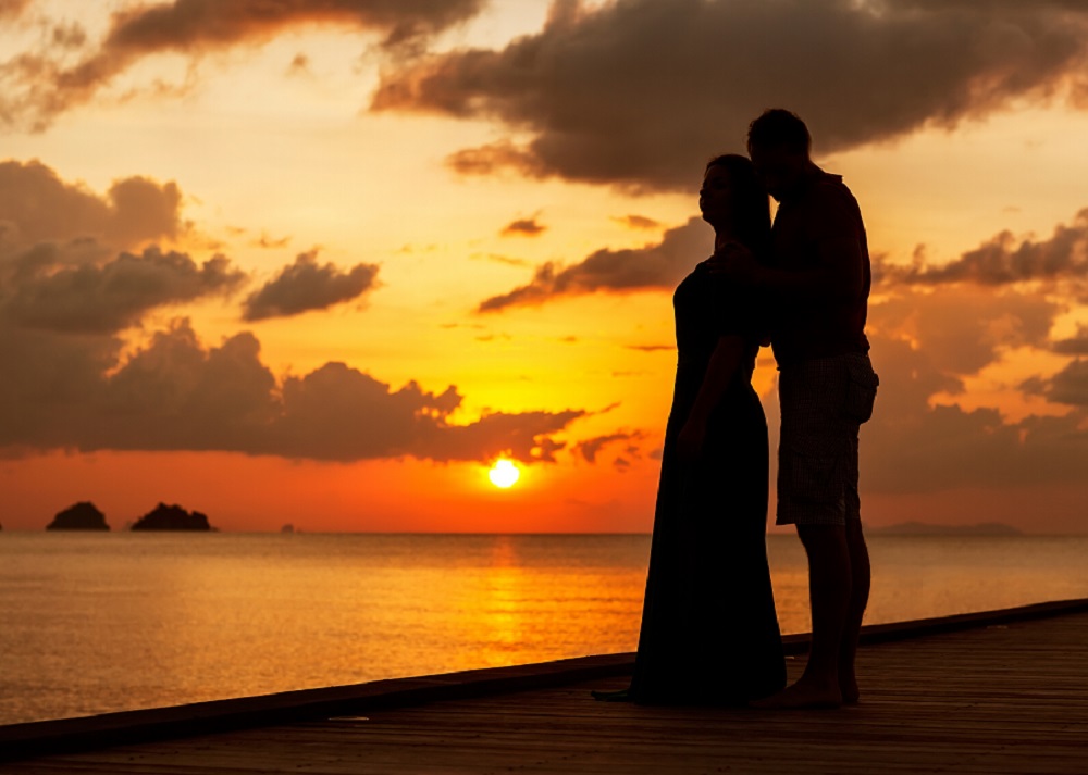 silhouette of couple embracing at sunset