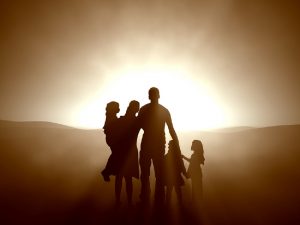 Silhouette of family holding hands at sunset