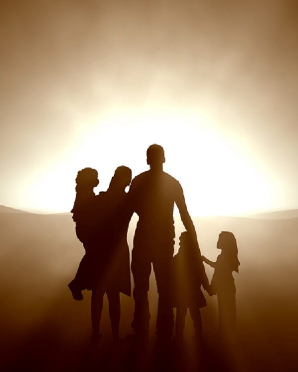 Silhouette of family holding hands at sunset